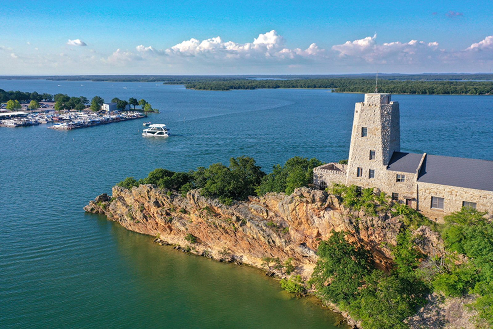 Aerial view of Tucker Tower on Lake Murray in Ardmore Oklahoma on a summer day with a houseboat in the distance