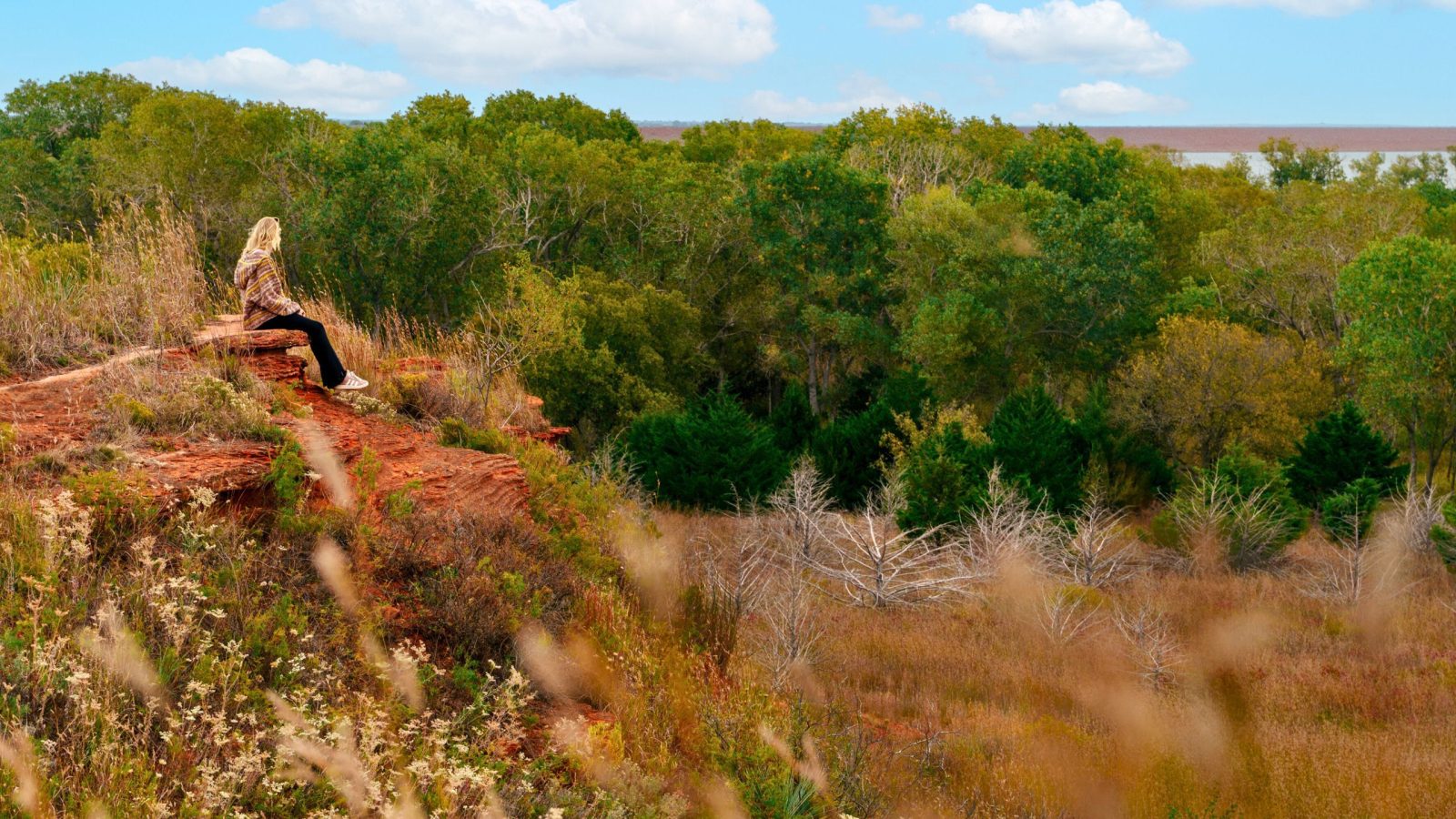 A young woman gazing across the great outdoors in Oklahoma. Oklahoma's diverse terrain makes its landscapes unique in the United States, and has ranked it as one of the top most outdoorsy states in the country.